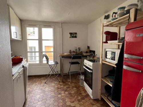 a kitchen with a red refrigerator and a table in it at BEST CENTRAL Chambres Privées - Seine & Louvre in the Connected Heart of Paris in Paris