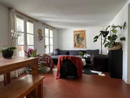 a living room with a couch and a table at Chambres privées dans grand T4-Paris plein-centre in Paris