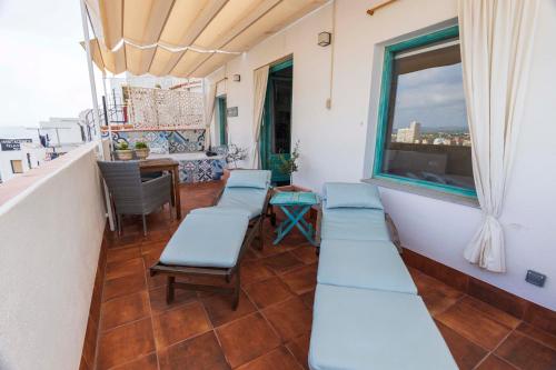a balcony with blue benches and a table and a window at Hostal Boutique Olvido 22 Adults Only in Peñíscola
