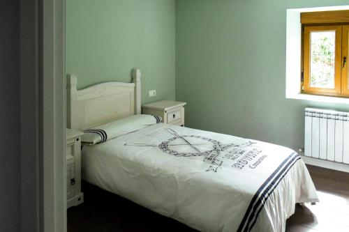 ein Schlafzimmer mit einem weißen Bett und einem Fenster in der Unterkunft Casa Villa Franca in Llamas de la Ribera