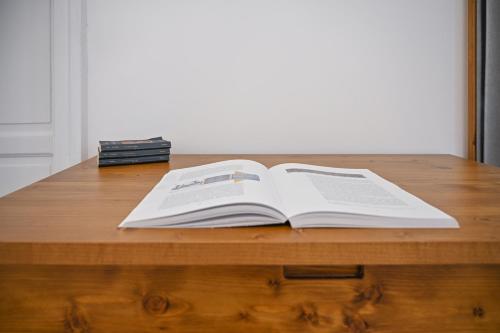 an open book sitting on top of a wooden table at Dimora Savarino Marzamemi Suites with pool in Marzamemi