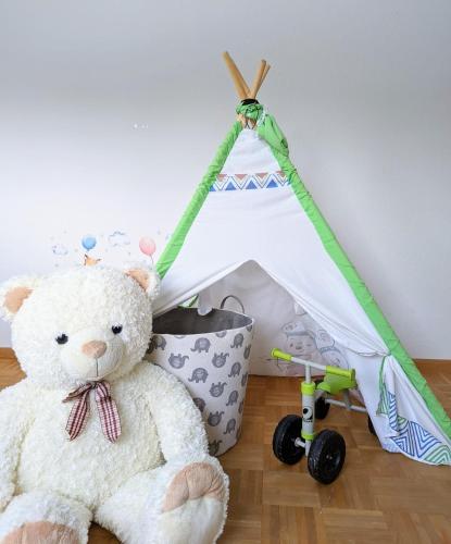 a teddy bear sitting next to a play tent at Rheinquartier Küssaberg Rheinheim in Küssaberg