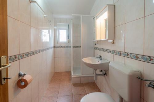 een badkamer met een toilet en een wastafel bij Apartments Besa in Pirovac
