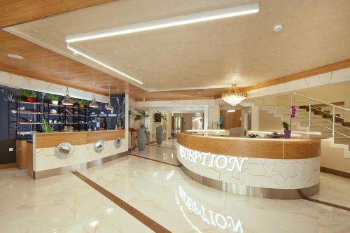a large lobby with a reception desk and a pharmacy at Hotel Golden Dune in Sunny Beach