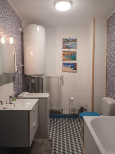 a bathroom with two sinks and a toilet at Appartement chaleureux de 82M2 proche de Vulcania in Pontaumur