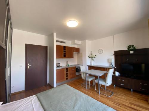 a living room with a kitchen and a table with a desk at Silver Apartments in Wrocław