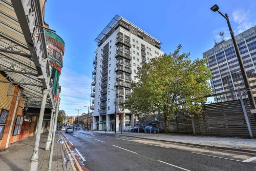 een lege straat met een hoog appartementencomplex bij The Cardiff Apartment in Cardiff