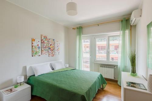 - une chambre avec un lit vert et une fenêtre dans l'établissement Cinecittà incantevole e moderno 2+2+1 AC WiFi, à Rome