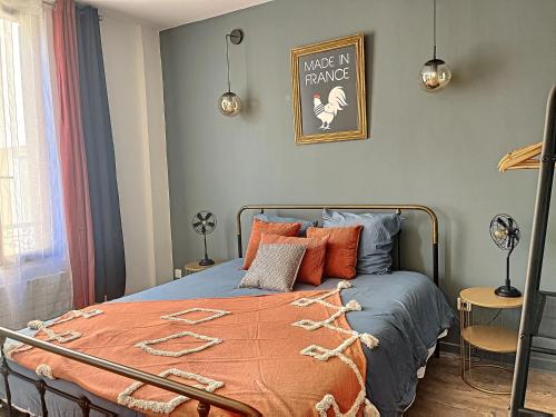 sypialnia z łóżkiem z pomarańczowym kocem w obiekcie Maison de ville - Paris en 15 mn ! - 4 pers- 1 bébé - Vintage & Music ! w mieście Groslay