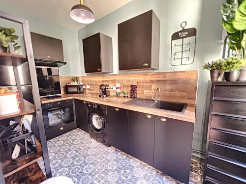 une cuisine avec un évier et une machine à laver dans l'établissement Maison de ville - Paris en 15 mn ! - 4 pers- 1 bébé - Vintage & Music !, à Groslay
