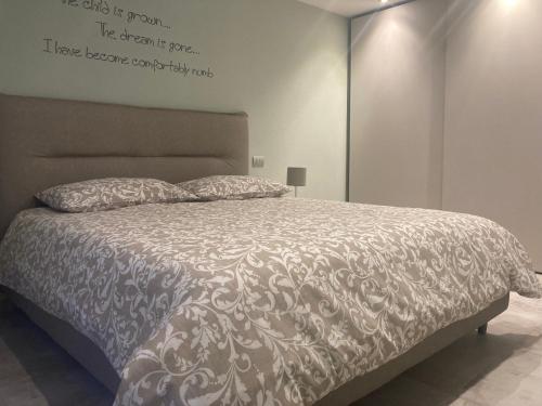 a bedroom with a bed with a white comforter at Senin House in Aosta