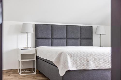 a bedroom with a large bed and two lamps at VILLA AIDO in Palanga