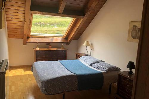 Un dormitorio con una cama grande y una ventana en Lovely triplex apartment in La vall de Boi en Pla de l'Ermita
