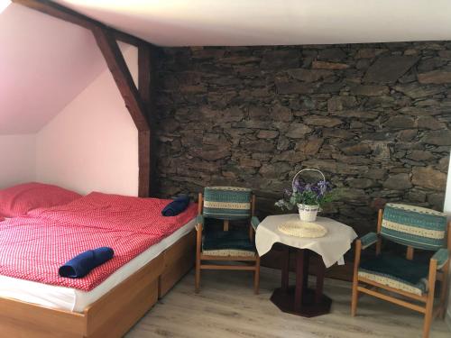 a bedroom with a bed and a table and chairs at U Monka - Jáchymov Klínovec in Jáchymov