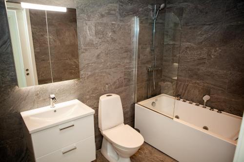 ein Badezimmer mit einem WC, einem Waschbecken und einer Badewanne in der Unterkunft Rösholmens Havsboende in Kungshamn
