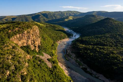 an aerial view of a river in the mountains at Matatane Camp - Babanango Game Reserve in Nkwalini
