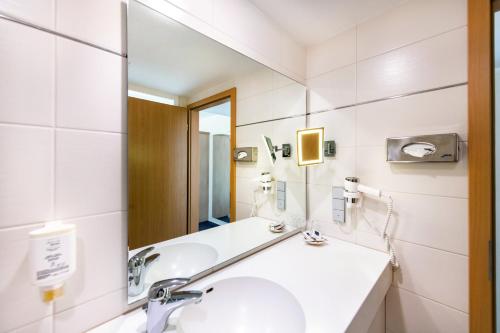 a bathroom with a sink and a mirror at Diehls Hotel in Koblenz