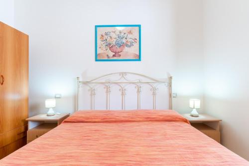 a bedroom with a large bed with two lamps at Residence La Perla - Ametista in Pizzo