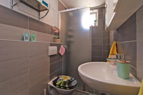 a small bathroom with a sink and a toilet at Apartment Leo 2180 in Krnica