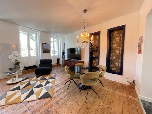 een woonkamer met een tafel en stoelen bij Appartement de grand standing in Saintes