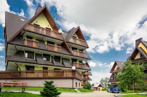 a tall building with a gambrel roof at Apartamenty Rodzinne II ApartZakop in Zakopane