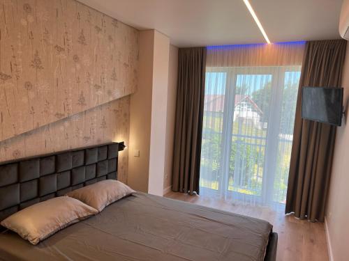 a bedroom with a bed and a large window at Apartamentai Pas Liną in Nida