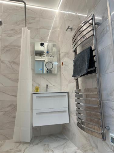 a white bathroom with a sink and a shower at Apartamentai Pas Liną in Nida