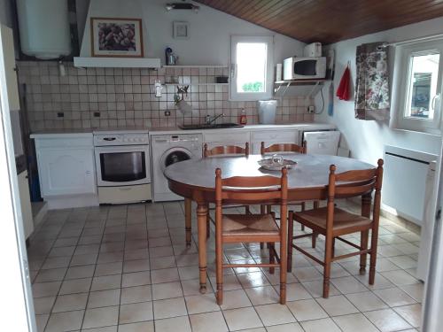 une cuisine avec une table et des chaises dans l'établissement maison de vacances à SAINT MARTIN DE BREHAL près de GRANVILLE, à Saint Martin de Brehal