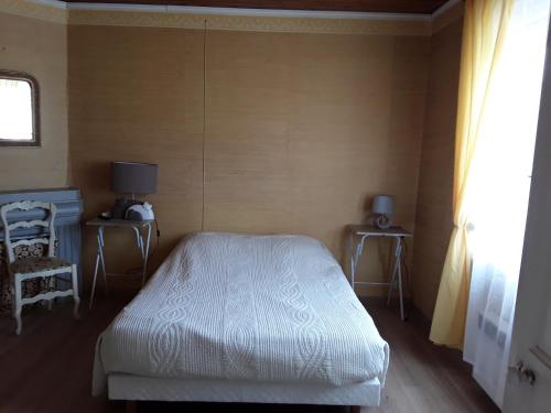 une chambre avec un lit, une chaise et une fenêtre dans l'établissement maison de vacances à SAINT MARTIN DE BREHAL près de GRANVILLE, à Saint Martin de Brehal