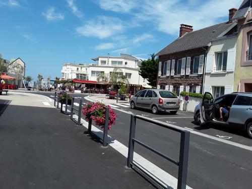 une rue avec des voitures garées sur le bord de la route dans l'établissement maison de vacances à SAINT MARTIN DE BREHAL près de GRANVILLE, à Saint Martin de Brehal