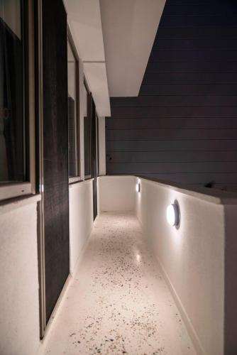 a hallway with a room with a white floor and lights at BE BOLD HOSTEL in Antalya