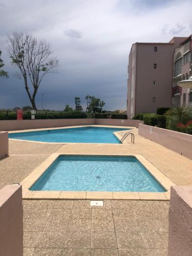 une grande piscine devant un immeuble dans l'établissement Superbe logement en bord de mer, au Cap d'Agde