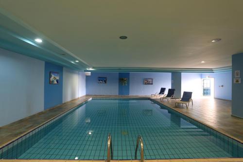 a swimming pool in a building with blue walls at Eleni Holiday Resort in Paphos City
