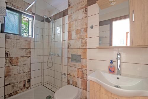 a bathroom with a sink and a toilet and a shower at Andromaches apartment sea view in Achílleion