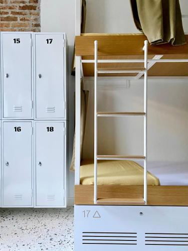a room with a bunk bed with a ladder and cabinets at BE BOLD HOSTEL in Antalya