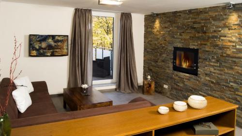 a living room with a couch and a fireplace at Hotel Koch Schilt in Irrel
