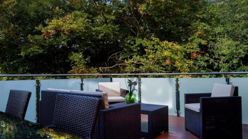 a balcony with chairs and a table and trees at Hotel Koch Schilt in Irrel