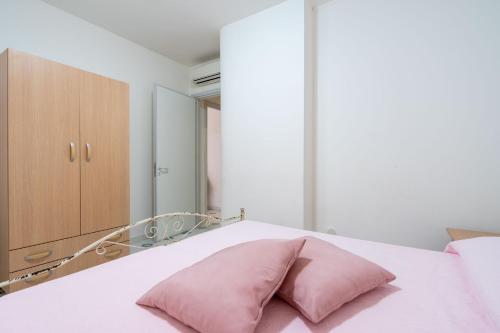 almohada rosa en una cama con espejo en Residence La Perla - Opale, en Pizzo
