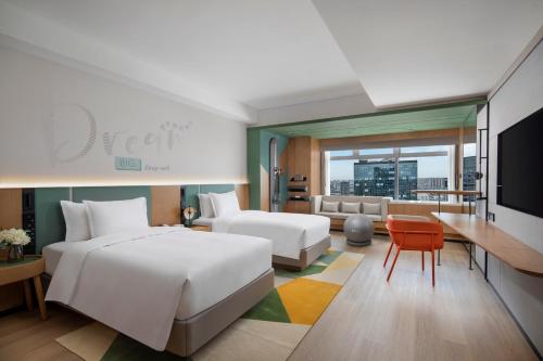 成都市にあるEVEN Hotel Chengdu Jinniu, an IHG Hotelのベッドとリビングルームが備わるホテルルームです。