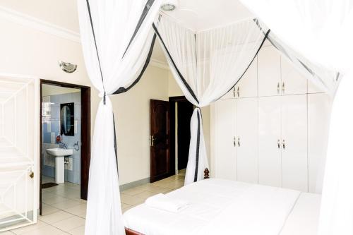 Schlafzimmer mit einem Bett mit Moskitonetz in der Unterkunft Luxury Acacia Villa with Kampala's Best View in Kampala