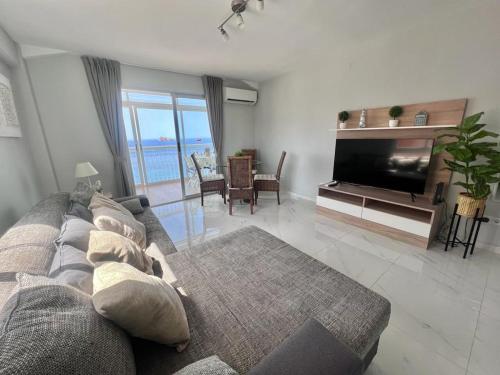 salon z kanapą i telewizorem z płaskim ekranem w obiekcie Apartamento Veracruz - Primera Linea de Playa w mieście Benidorm