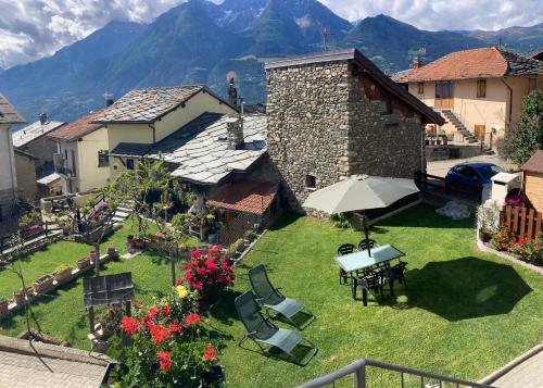 a garden with a table and chairs and an umbrella at Senin House in Aosta