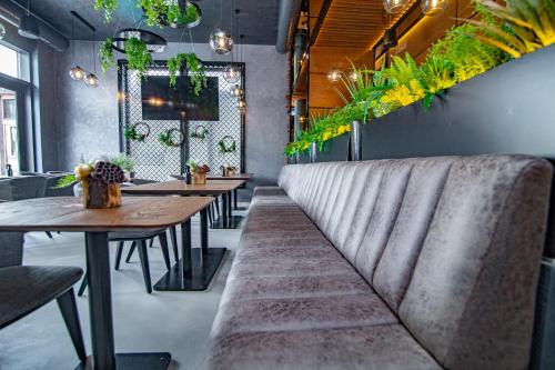 a row of tables in a restaurant with plants at Vila Maša Zlatibor in Zlatibor