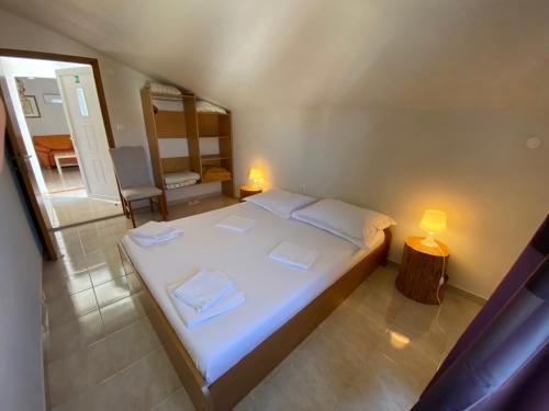 ein Schlafzimmer mit einem großen weißen Bett und einem Spiegel in der Unterkunft Apartments Istra Nielsen in Premantura