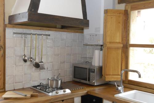 a kitchen with a stove and a microwave at La Casuca de Agüero in Agüero