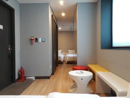 首爾的住宿－格瑞德酒店，浴室设有白色卫生间和红色凳子。