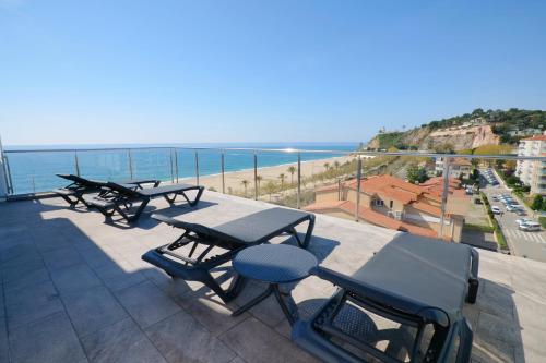 een balkon met tafels en stoelen en de oceaan bij Hotel Internacional in Calella