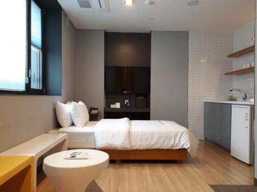 a bedroom with a bed and a table and a sink at Grid Inn Hotel in Seoul