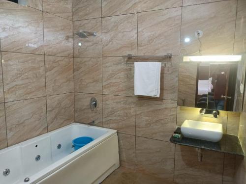 Hotel Rajwada palace في أورشها: حمام مع حوض ومغسلة