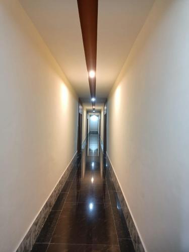 a corridor of an empty building with lights on the walls at Hotel Rajwada palace in Orchha